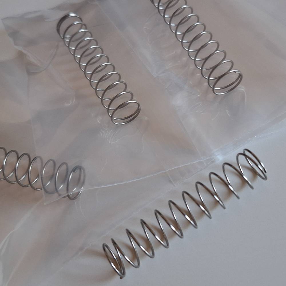 Four heavy duty magazine springs for Umarex T4E TP50 Compact Gen1 and Gen2, partially packaged in clear plastic bags
