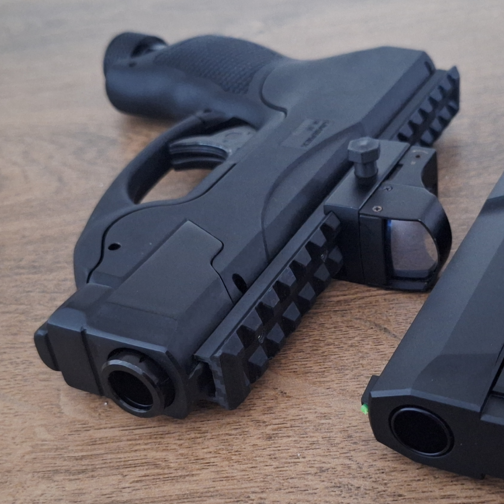 Side Close up angel of the HDP50 compact gen2 with a compensator, picatinny rail and RDS next to a HDP50 / TP50 Gen2 Dutch version. Showing the premium matte black finish